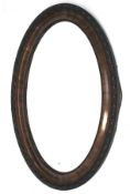 An Edwardian ebonised framed bevel edged oval wall mirror with carved decoration.