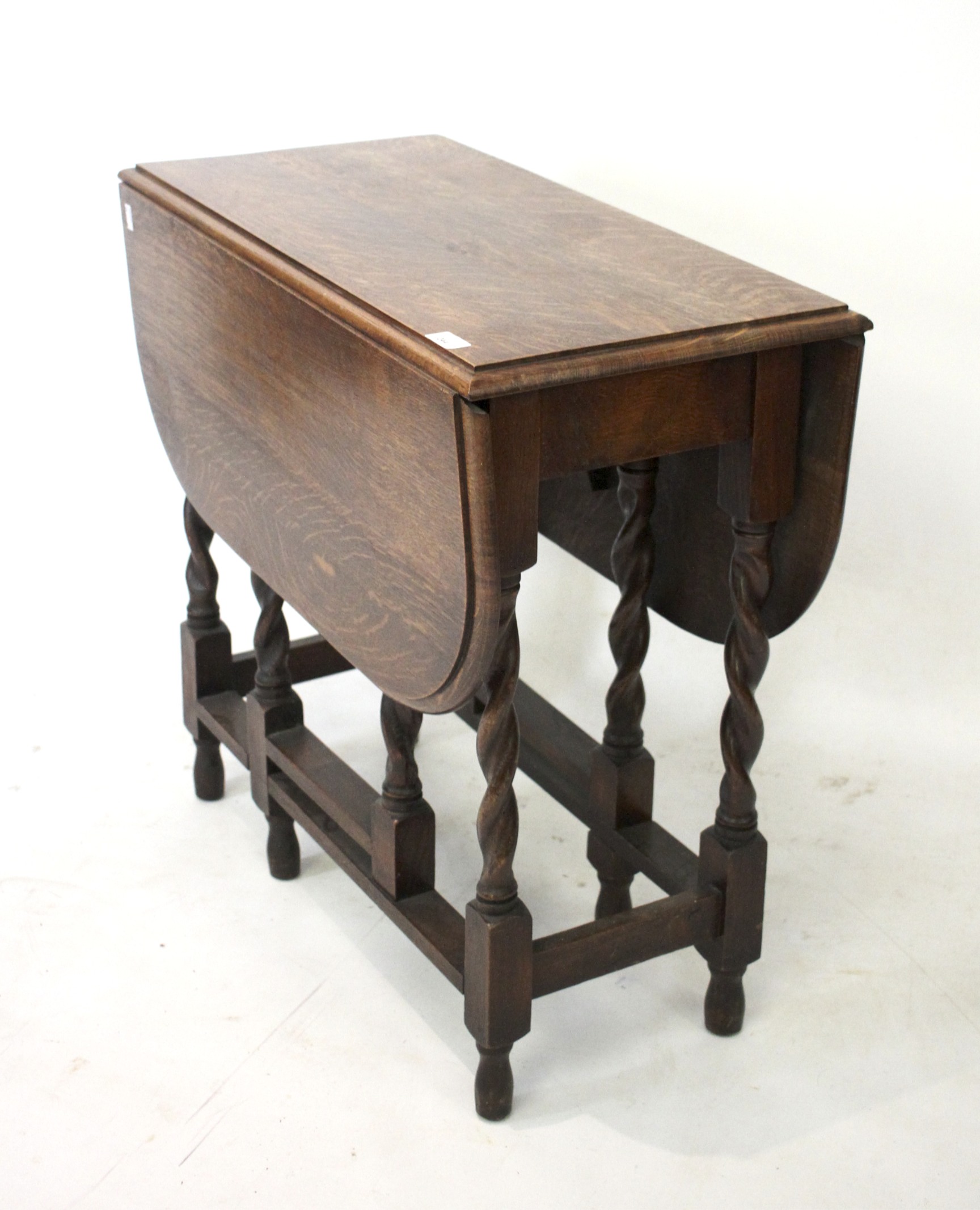 A 1930s oak drop leaf gate leg table. Raised on barley twist supports.