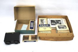 A vintage view finder with slides and assortment of photograph booklets.