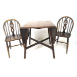 An oak Ercol drop leaf table and two chairs.