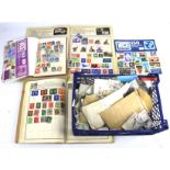 A basket of assorted stamp albums with an assortment of world stamps.