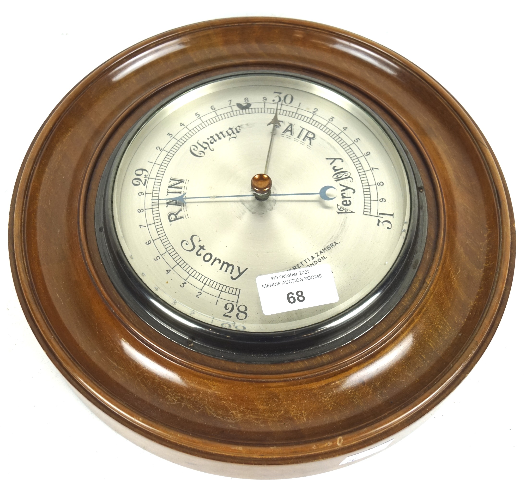 A circular wooden framed Negretti & Zambra London wall barometer.