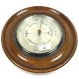 A circular wooden framed Negretti & Zambra London wall barometer.