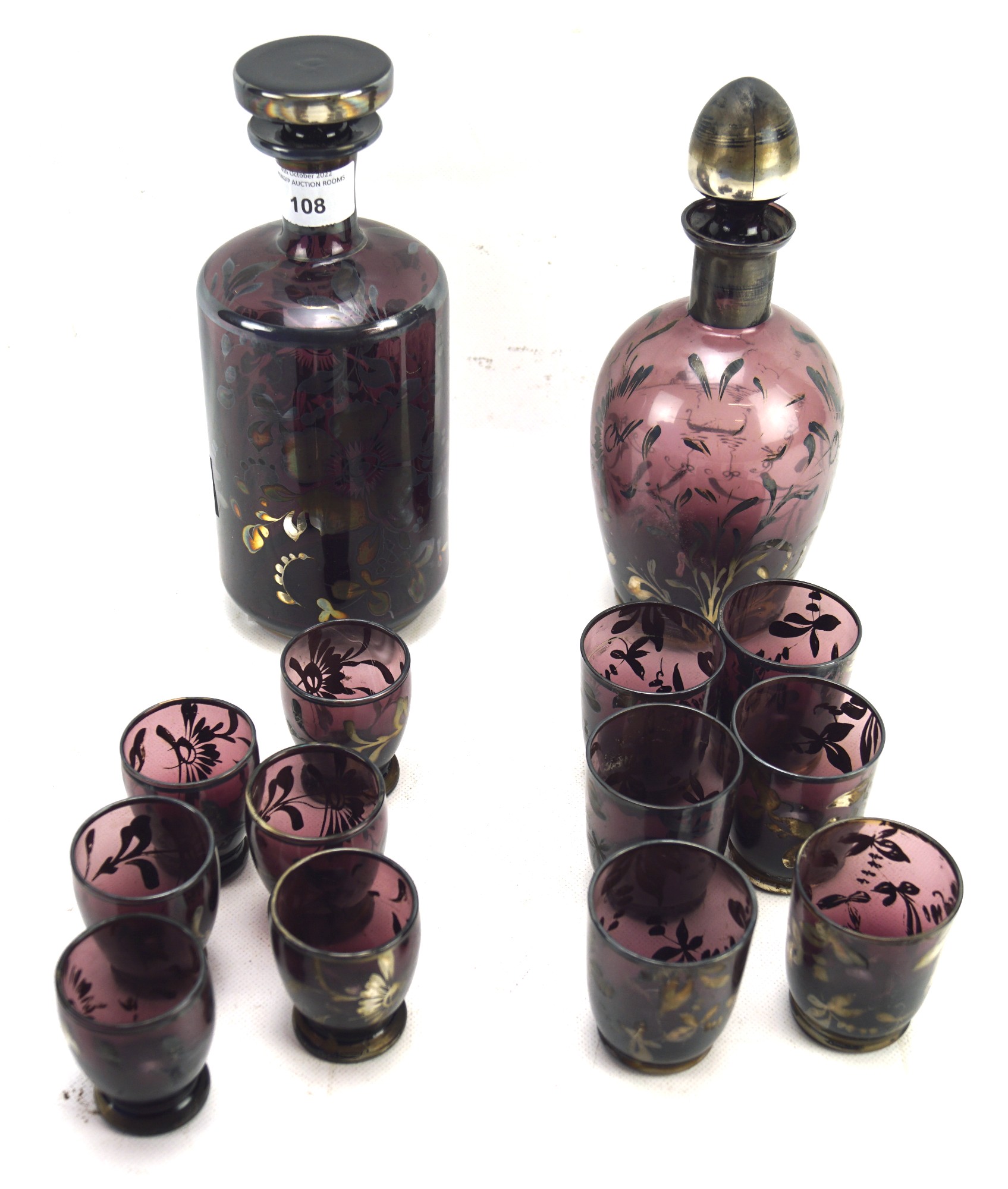 Two early 20th century glass decanters with matching glasses.