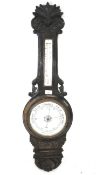 An ebonised aneroid banjo barometer.