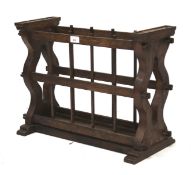 An oak Arts and Crafts magazine rack. With pierced sides and shaped supports. L56cm x D25.5cm x H41.
