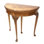 A burr walnut demi-lune foldover card table.