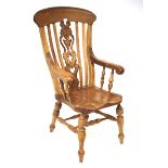 A 20th century pine Windsor elbow chair. Monogrammed to the central splat, H122.