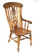 A 20th century pine Windsor elbow chair. Monogrammed to the central splat, H122.