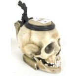 An unusual novelty porcelain tankard in the form of a human skull.