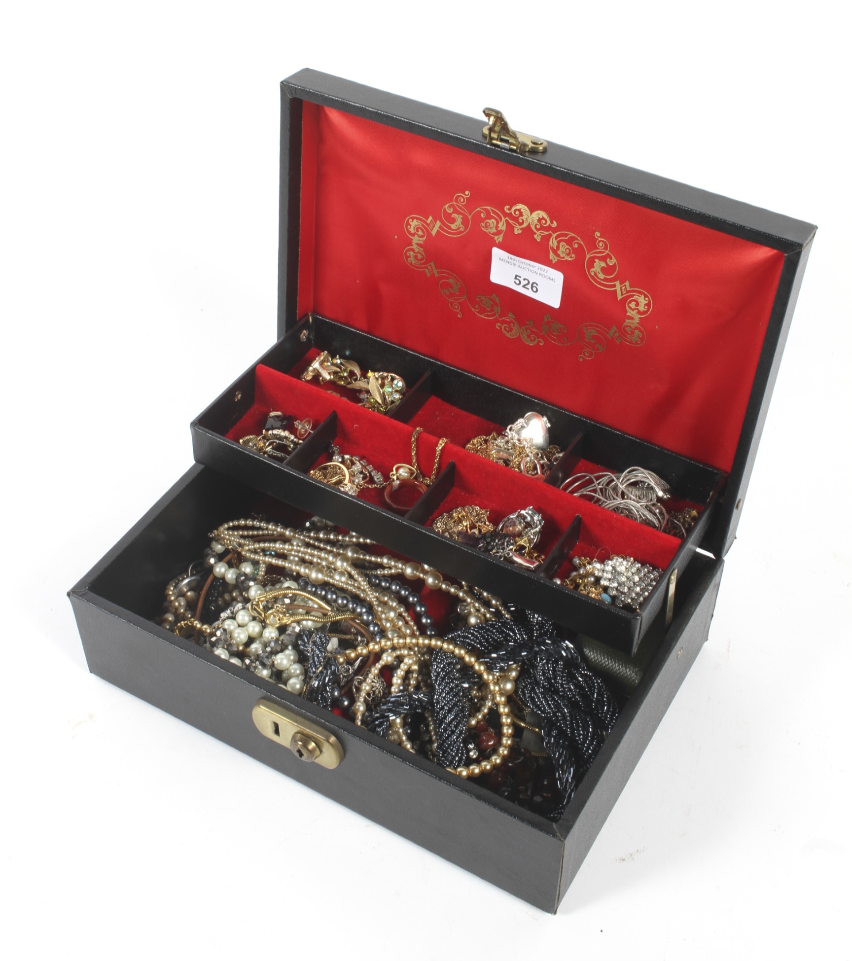An assortment of vintage jewellery housed in a tiered jewellery box.