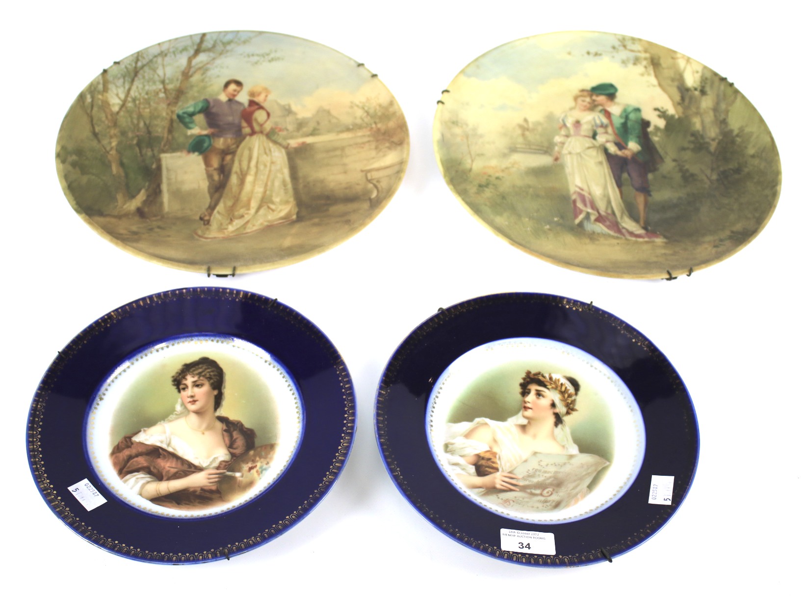 A pair of painted glass chargers and two French porcelain portrait plates.