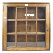 A mid-century oak wall hanging display cabinet. With glazed single door, lock and key.