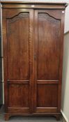 An oak wardrobe with carved arched panels.