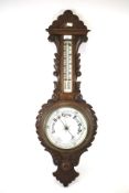 An oak aneroid wall barometer with Fahrenheit and centigrade thermometer.