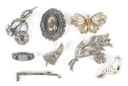 A collection of eight vintage ladies white metal brooches.