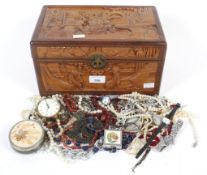 An assortment of costume jewellery and beads in a Chinese carved wood box.