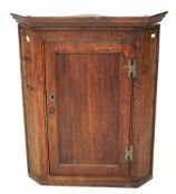 A 19th century oak corner cabinet. With shaped pelmet, panelled door, and brass hinges, H100cm.