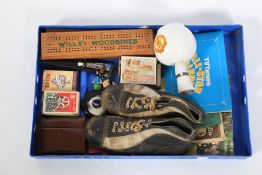 A box of assorted ephemera. Including football boots, playing cards, a trophy etc.