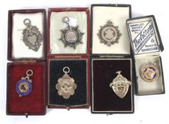 A collection of seven silver fob medals.