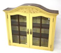 A painted, arched top glazed wall cabinet. The glazed doors opening to two internal shelves.