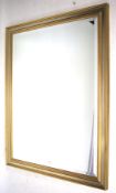 A large contemporary gilt framed wall mirror.