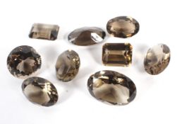 A collection of nine citrine and smoky quartz gemstones.