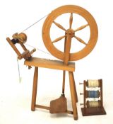 A vintage beech spinning wheel and bobbin holder with three bobbins.