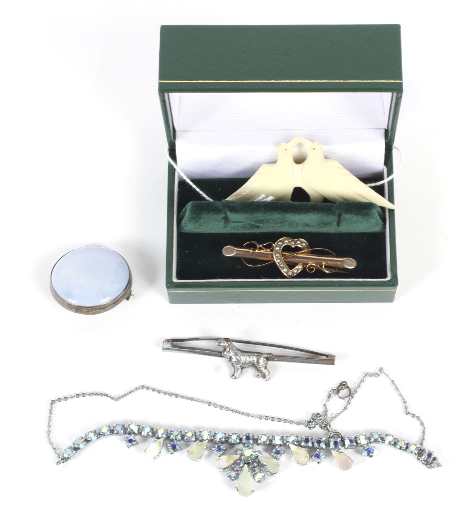 A 9ct gold sweetheart brooch set with seed pearls, a Ruskin silver brooch, and costume jewellery.