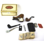 A box of smoking paraphernalia. Including pipes, cigarette cards, cigar items in a Cuban cigar box.