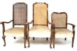 A pair of 20th century elbow chairs and a single elbow chair.