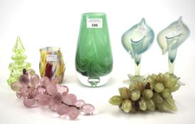 Assorted glass vessels and two bunches of grapes.