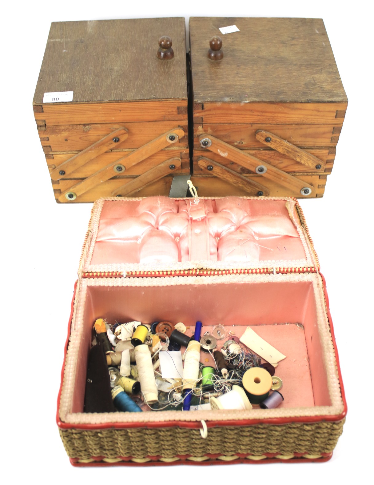 A vintage pine cantilevered sewing box and a wicker sewing basket and contents.