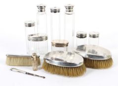 A late Victorian and later silver mounted set of bottles and brushes.
