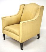 A Victorian armchair with gold coloured upholstery. Raised on squared supports to casters.