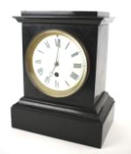 A Victorian slate mantel clock with Roman numerals denoting hours.