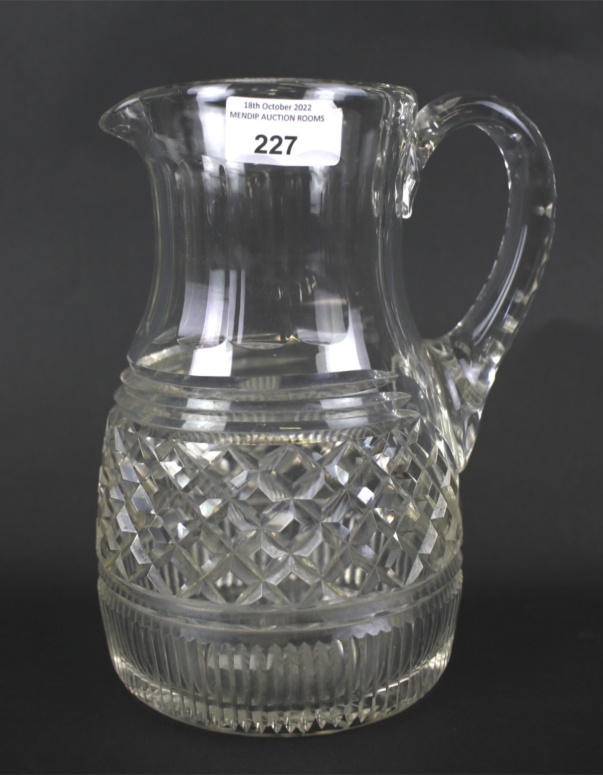 A lead crystal ewer with cut ribbed and cross-hatched design.