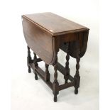 A 1930s oak drop leaf gate leg table. Raised on barley twist supports.