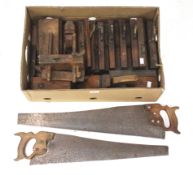 A box of assorted vintage planes and two saws.
