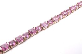 A modern 9ct gold and treated-pink-topaz line bracelet and a matching ring.