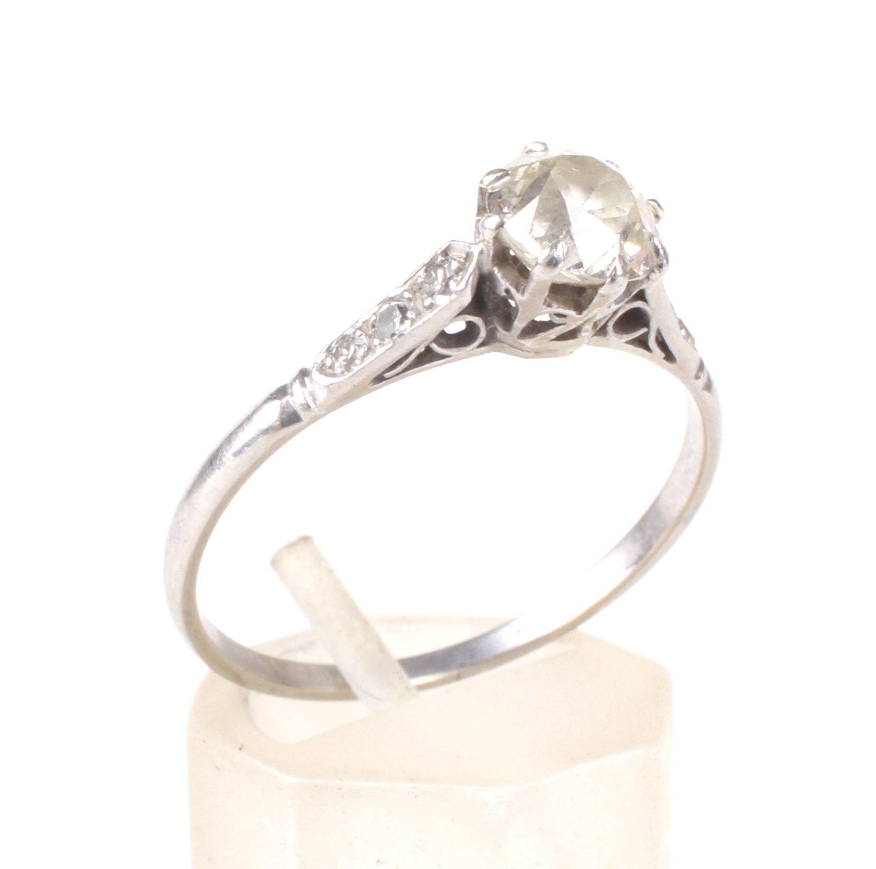 An early-mid 20th century platinum and diamond solitaire ring with small diamond shoulders.