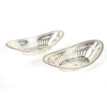 A pair of silver dishes, of oval form. With gadroon decorated rim and the body with.