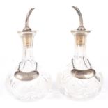 A pair of George V silver mounted glass bitters pourers by Hukin and Heath.