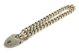An early 20th century gold curb link bracelet on a padlock clasp.