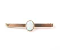 An early 20th century gold and opal single stone bar brooch.