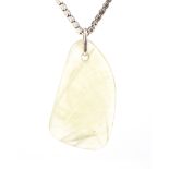 A Victorian gold chain hung with a later light-yellow jadeite pendant.