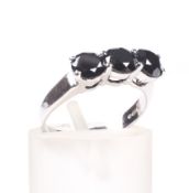 An 18ct white gold and black diamond three stone ring. The round brilliants each approx. 4.