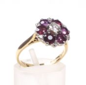 A vintage 18ct gold, ruby and diamond cluster ring. Centred with a round brilliant diamond approx.