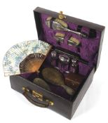 An early 20th century purple ladies leather cased travelling vanity set.