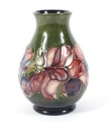 A Moorcroft Pottery Anemone pattern baluster green ground vase.